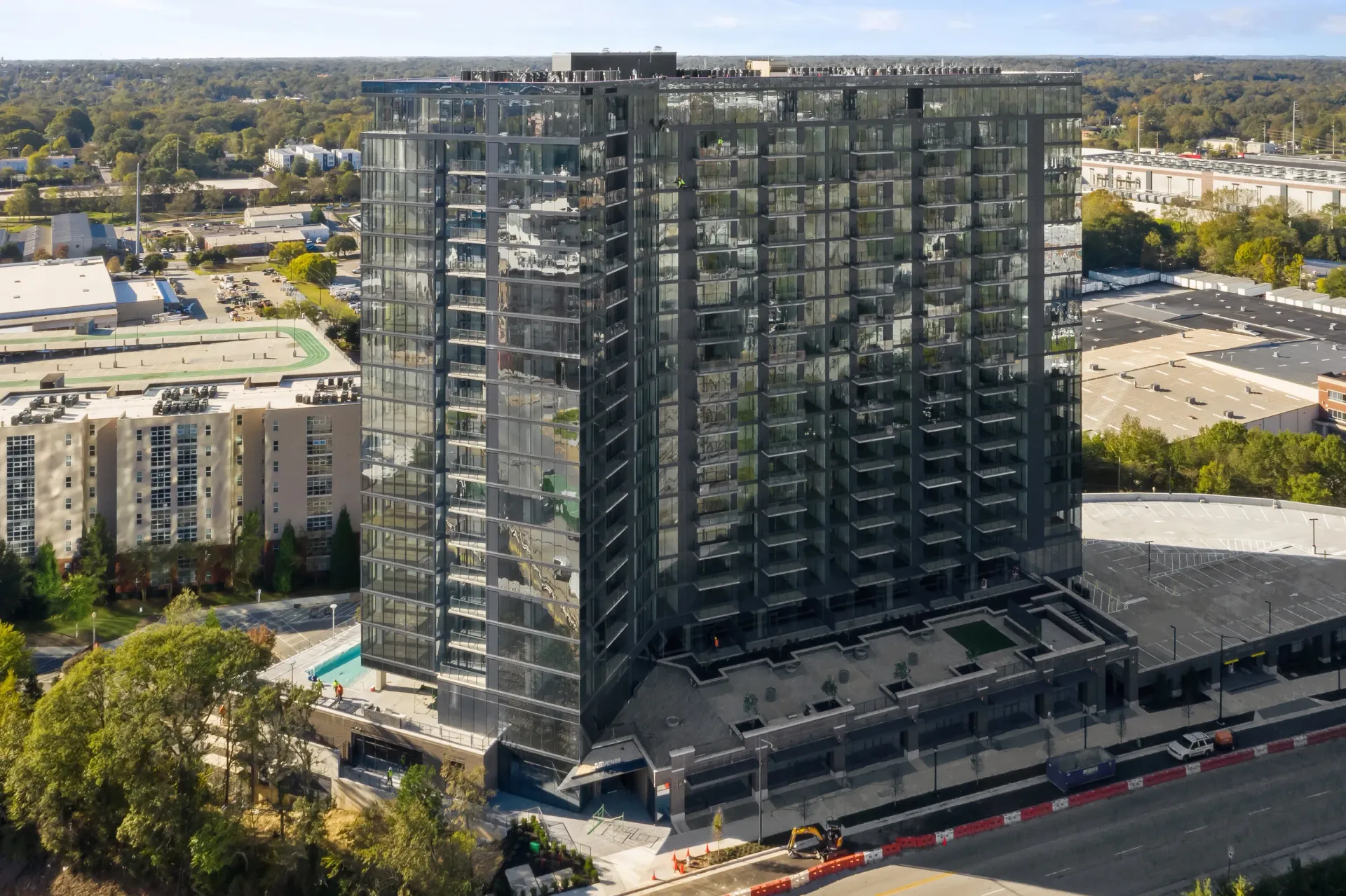 Modern glass high-rise apartment building with an outdoor swimming pool.