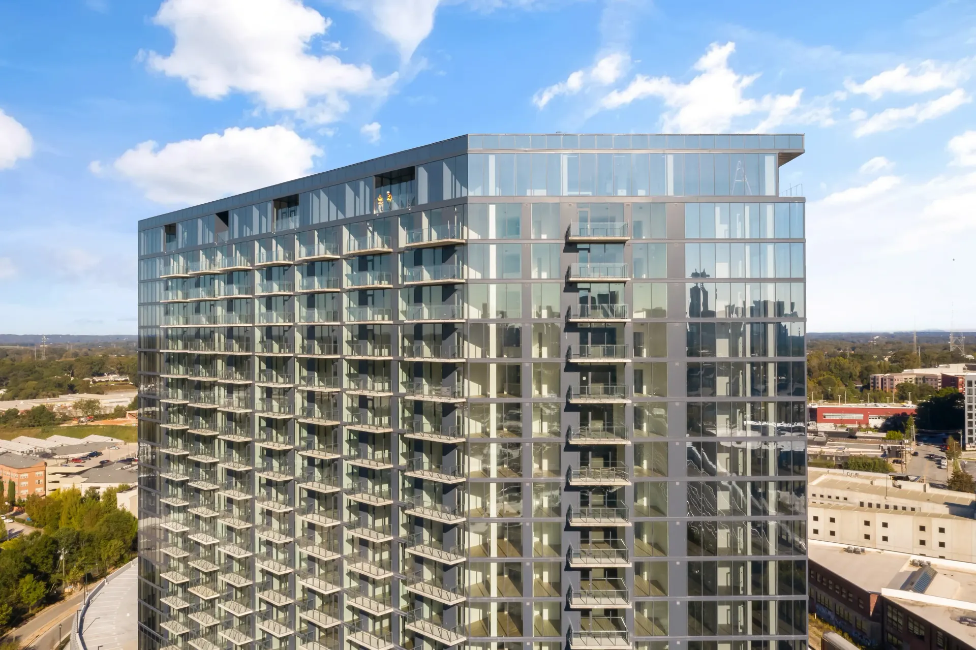 Modern high-rise apartment building with glass exterior and balconies.