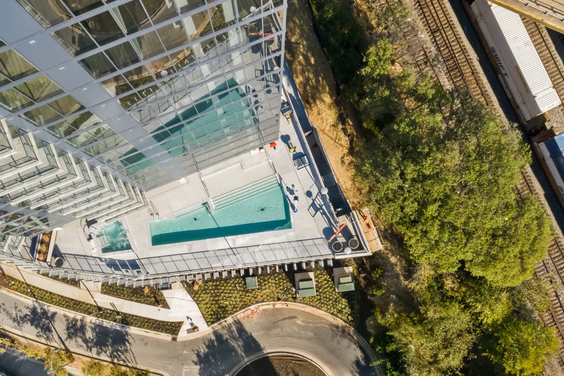 Aerial view of a modern apartment building with a swimming pool and hot tub.