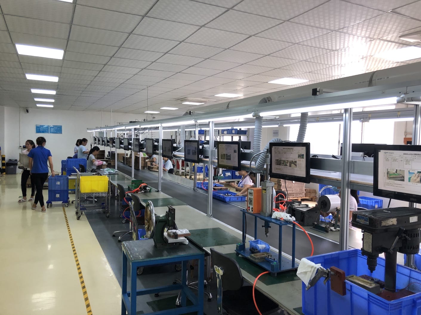 A factory with a conveyor belt and a lot of people working in it.