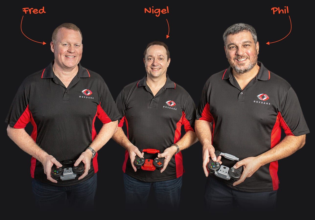 Three men are standing next to each other holding remote controls.