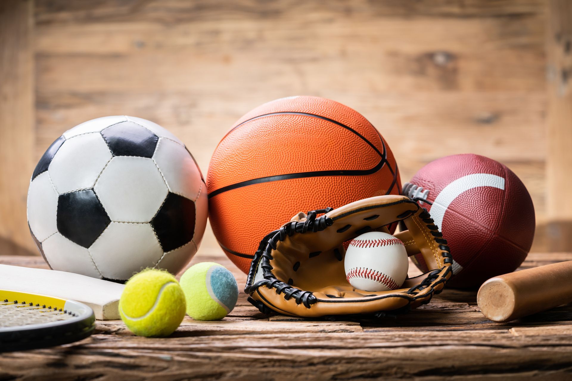 There are many different types of sports balls on the table.