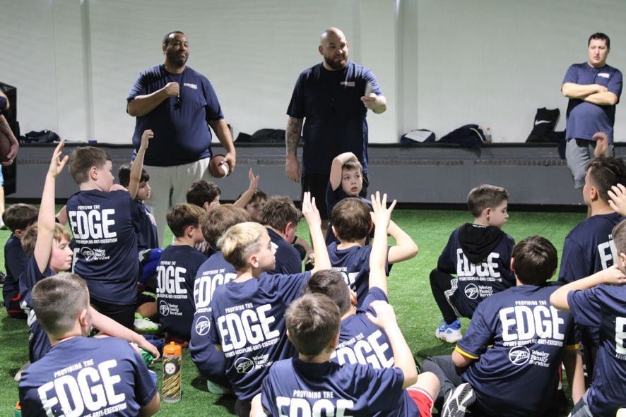 A group of young boys in red shirts are standing in a circle.