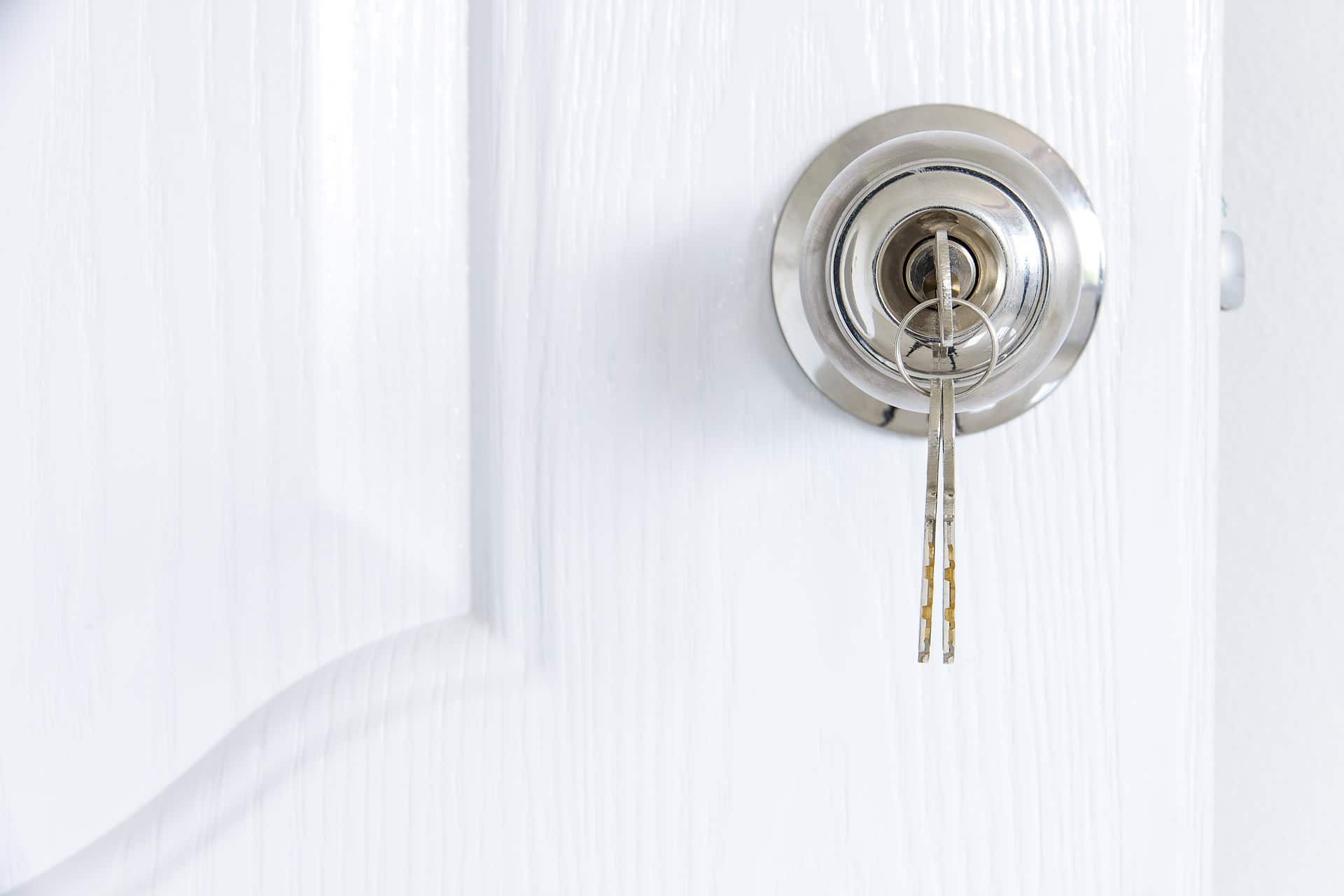 A Close Up Of A Key In A Lock On A White Door — Eddie Williams Locksmiths in Cairns City, QLD