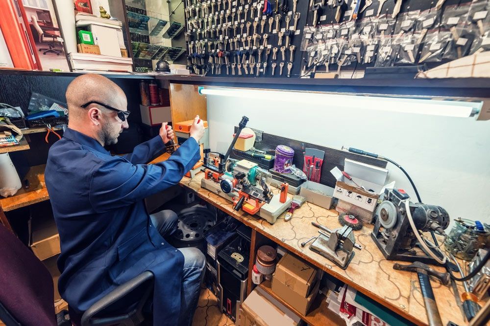 A Man Is Sitting At A Desk Working On A Computer — Eddie Williams Locksmiths in Cairns City, QLD