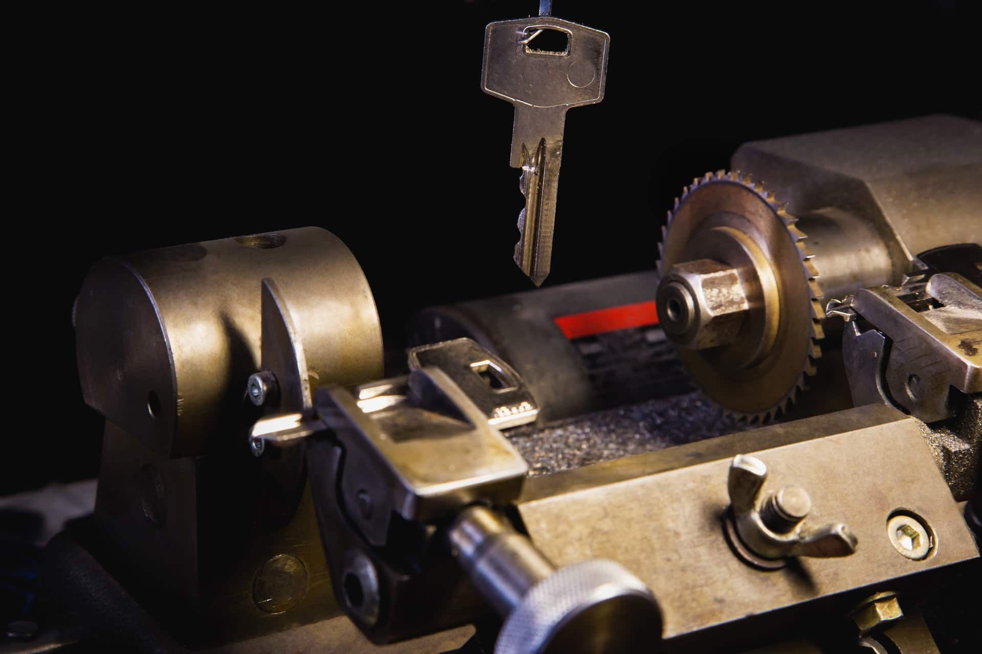 A Machine Is Cutting A Key On A Black Background — Eddie Williams Locksmiths in Cairns City, QLD