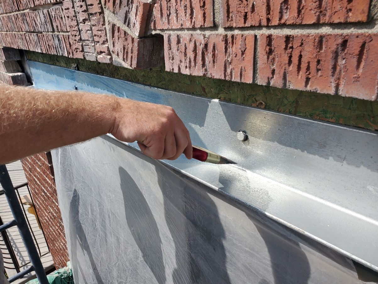 Une personne peint un mur de briques avec un pinceau