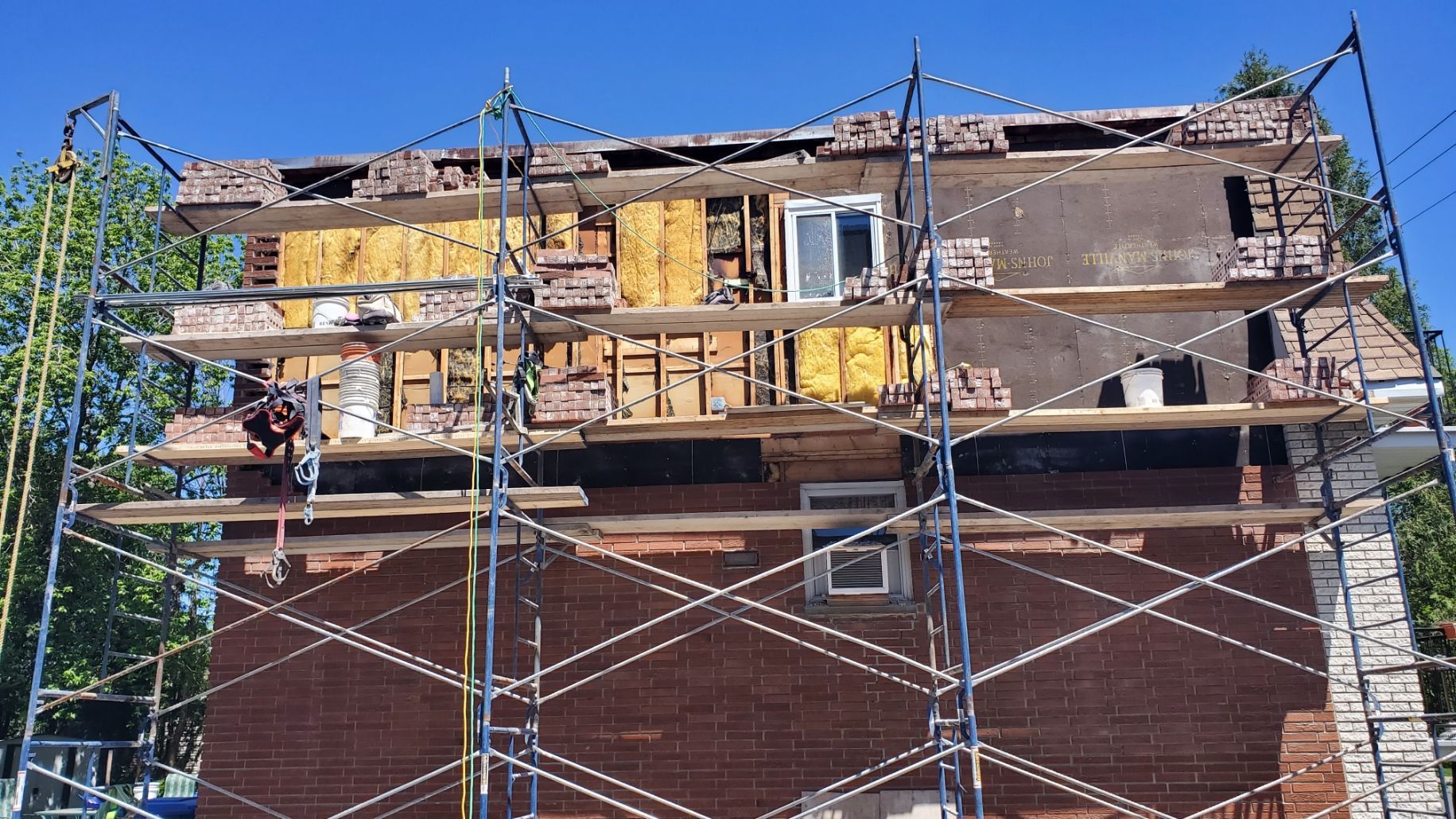 Un bâtiment en briques en construction avec des échafaudages autour