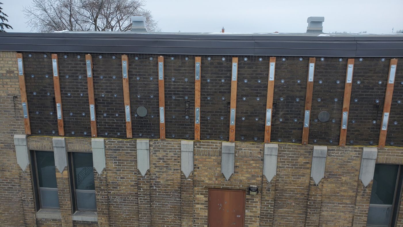 Une vue aérienne d'un bâtiment en briques avec un toit et une porte.