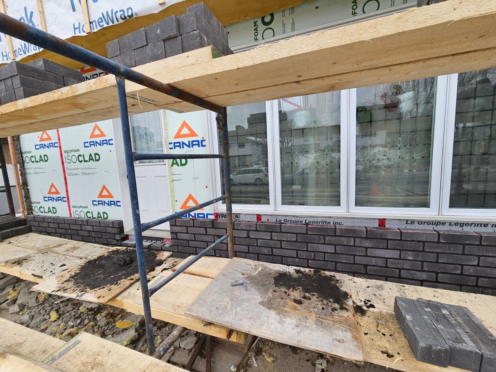 Un bâtiment est en cours de construction avec des échafaudages et des briques.