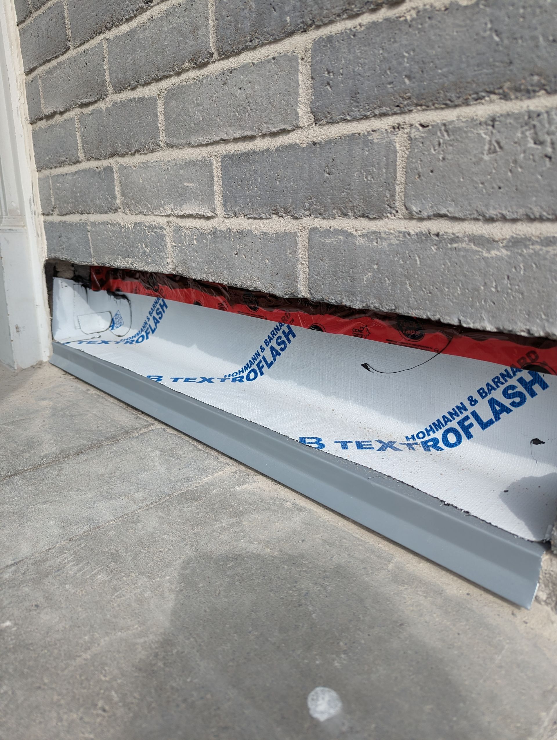 Un mur de briques avec un drain sur le côté.