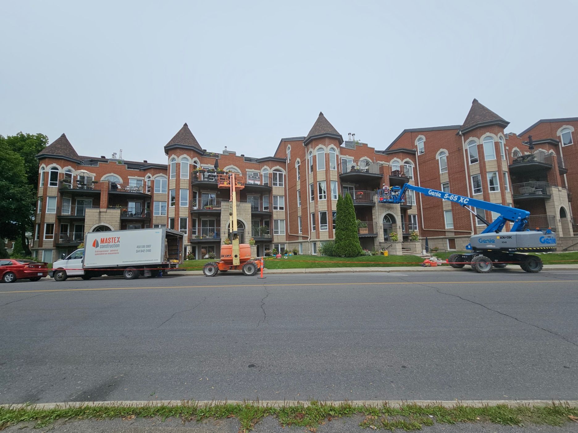 Un camion blanc est garé devant un grand bâtiment.