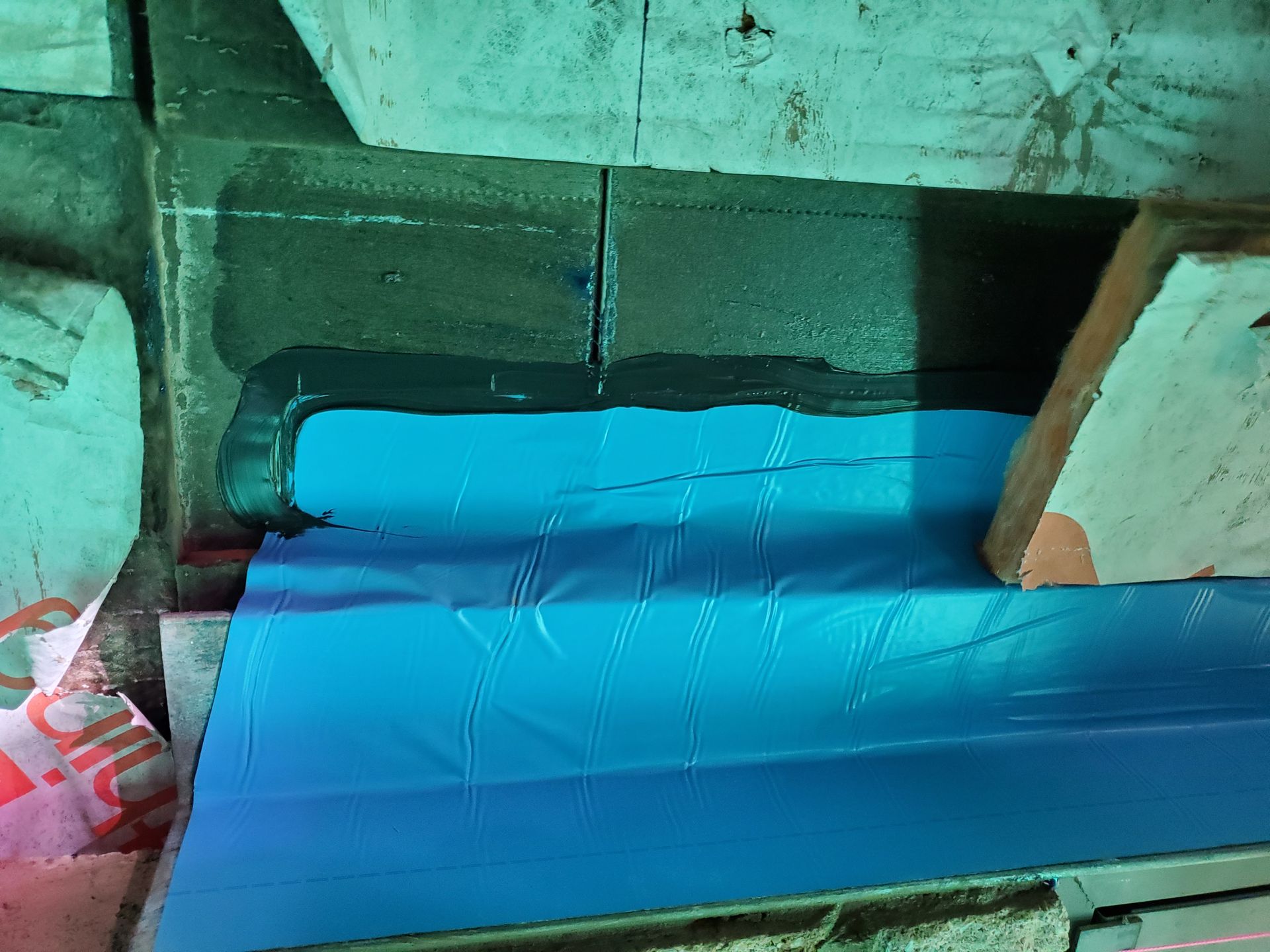 Un morceau de plastique bleu est posé sur un morceau de bois.