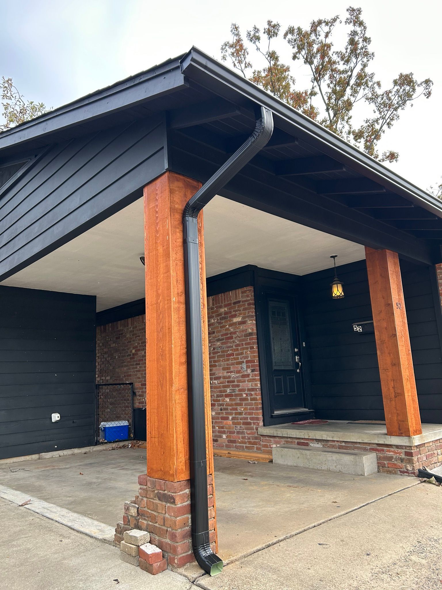 clapboard wood siding and all trim in black. 5” seamless gutters and downspouts in black