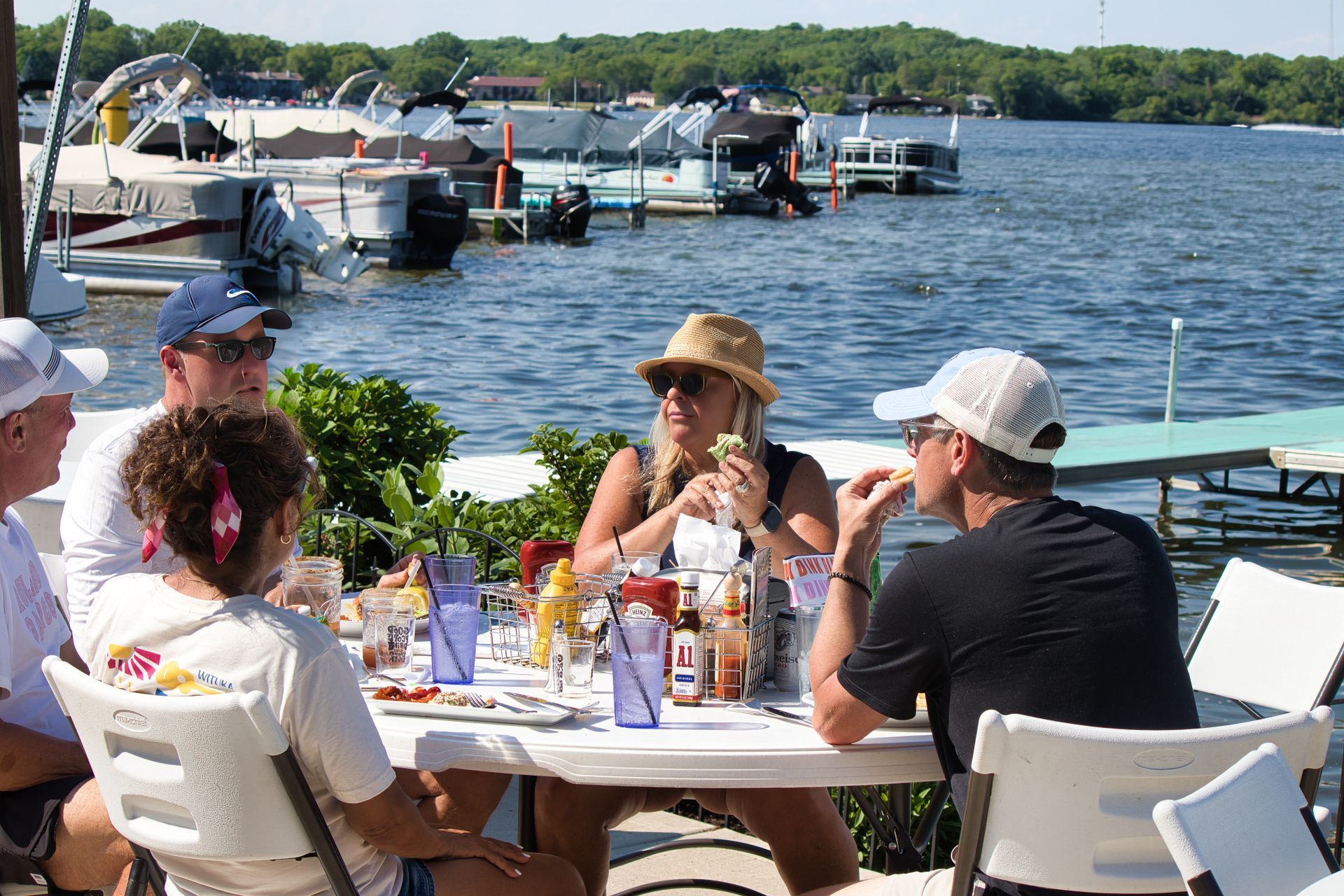 Guests dining beside Silver Lake with boats in the background.