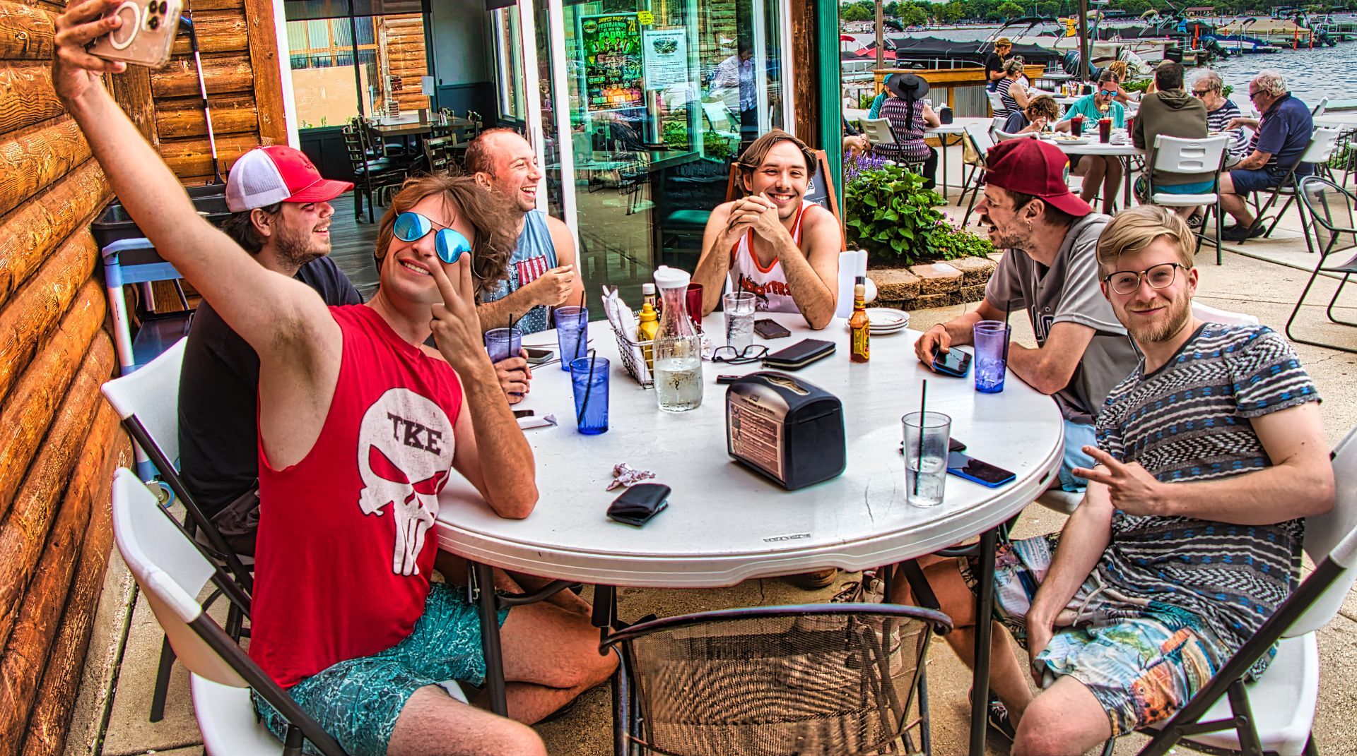 Guests taking a selfie at a Copper Bottom patio table.