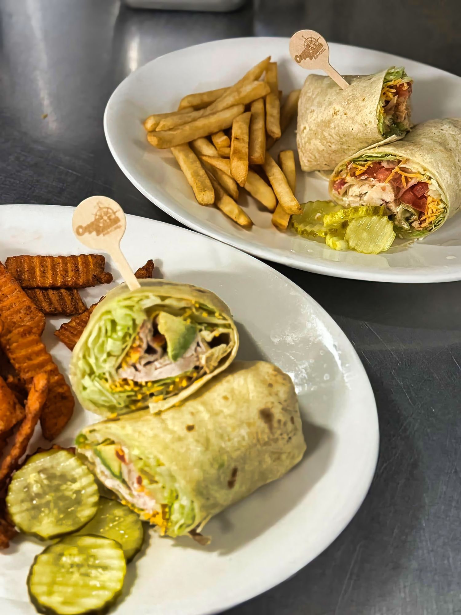 Wraps served with fries and pickles.