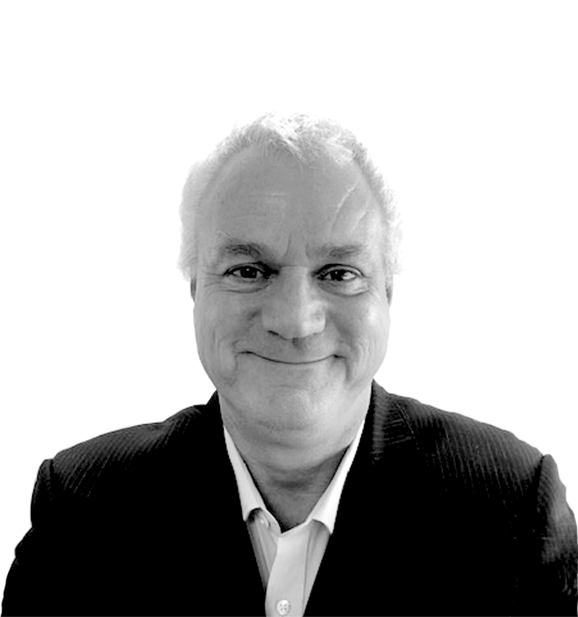 Smiling man in black suit and open-collared white shirt.