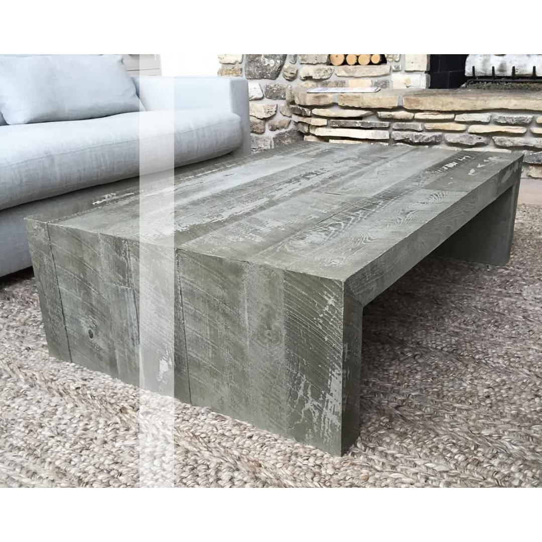 A concrete coffee table is sitting in a living room next to a couch.