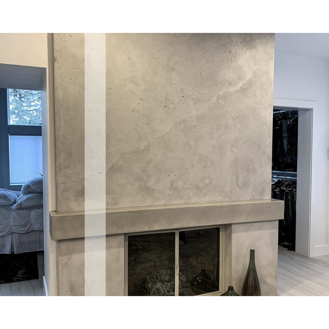 There is a concrete fireplace in the middle of the room.