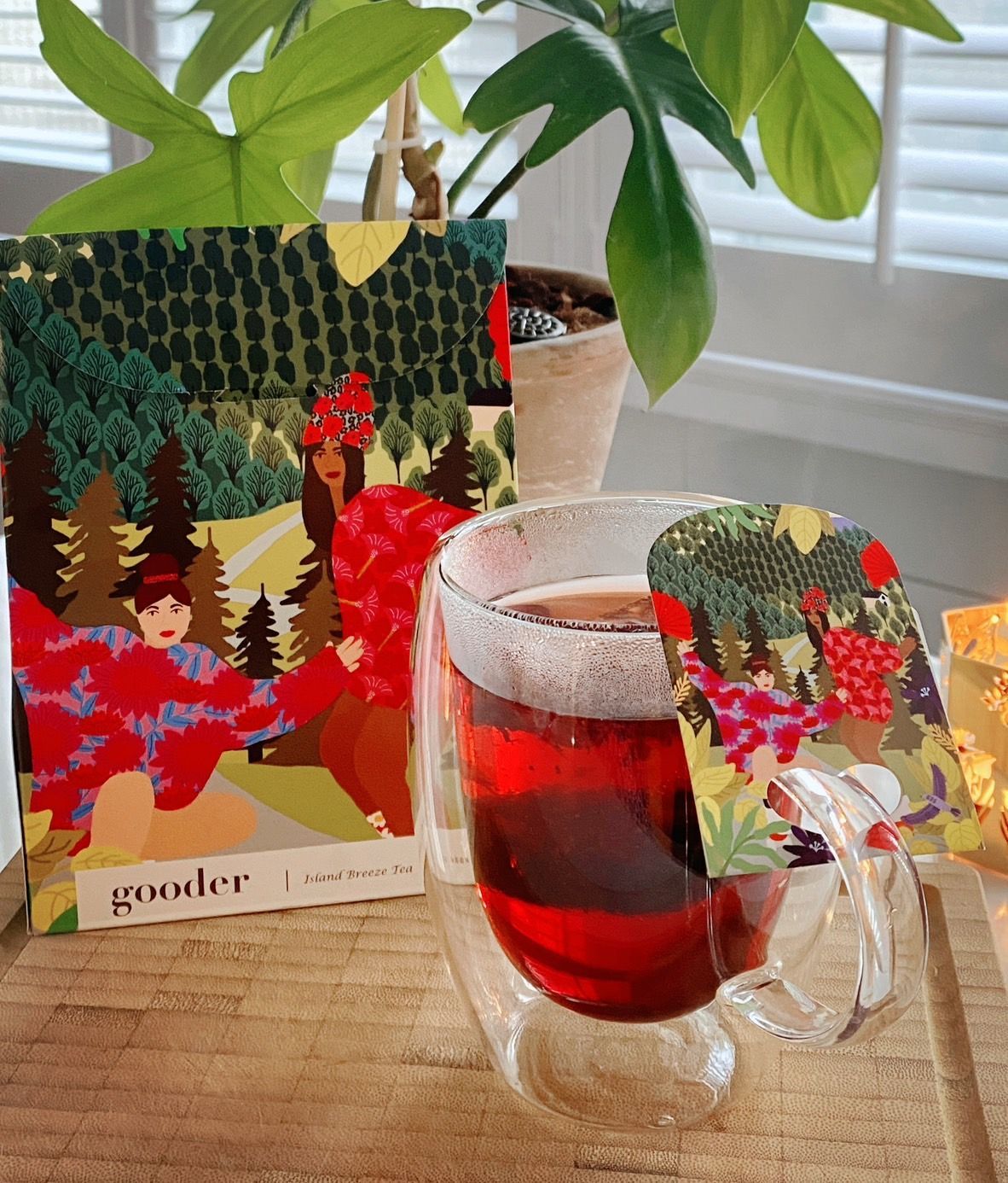 窗台上，一杯紅茶擺放在一張色彩鮮豔的節慶賀卡和一個禮品袋旁。