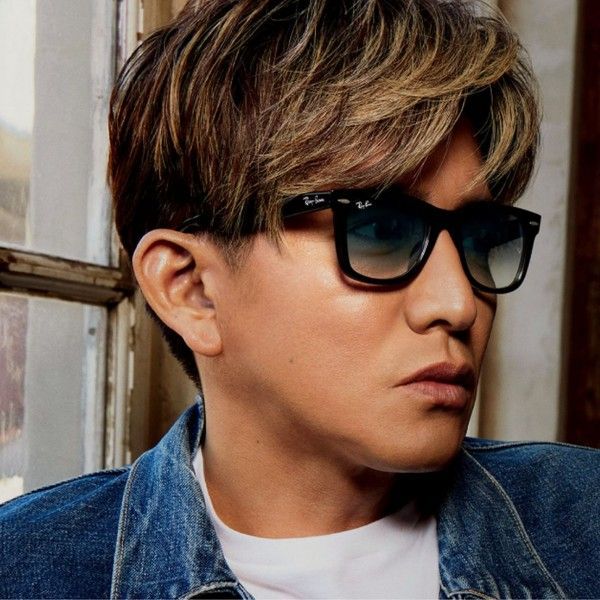 一名戴著黑色太陽眼鏡、身穿牛仔夾克的男子，正側身看向室內。