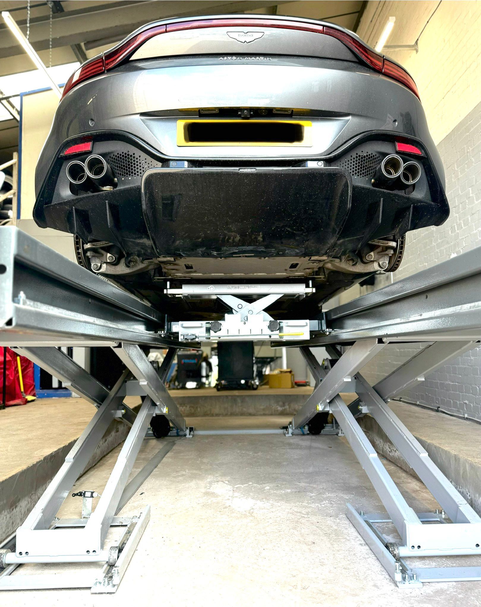 Aston Martin on the ramp receiving a Hunter Wheel Alignment Check