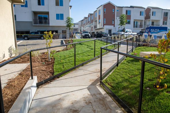 A walkway with a railing leading to a building