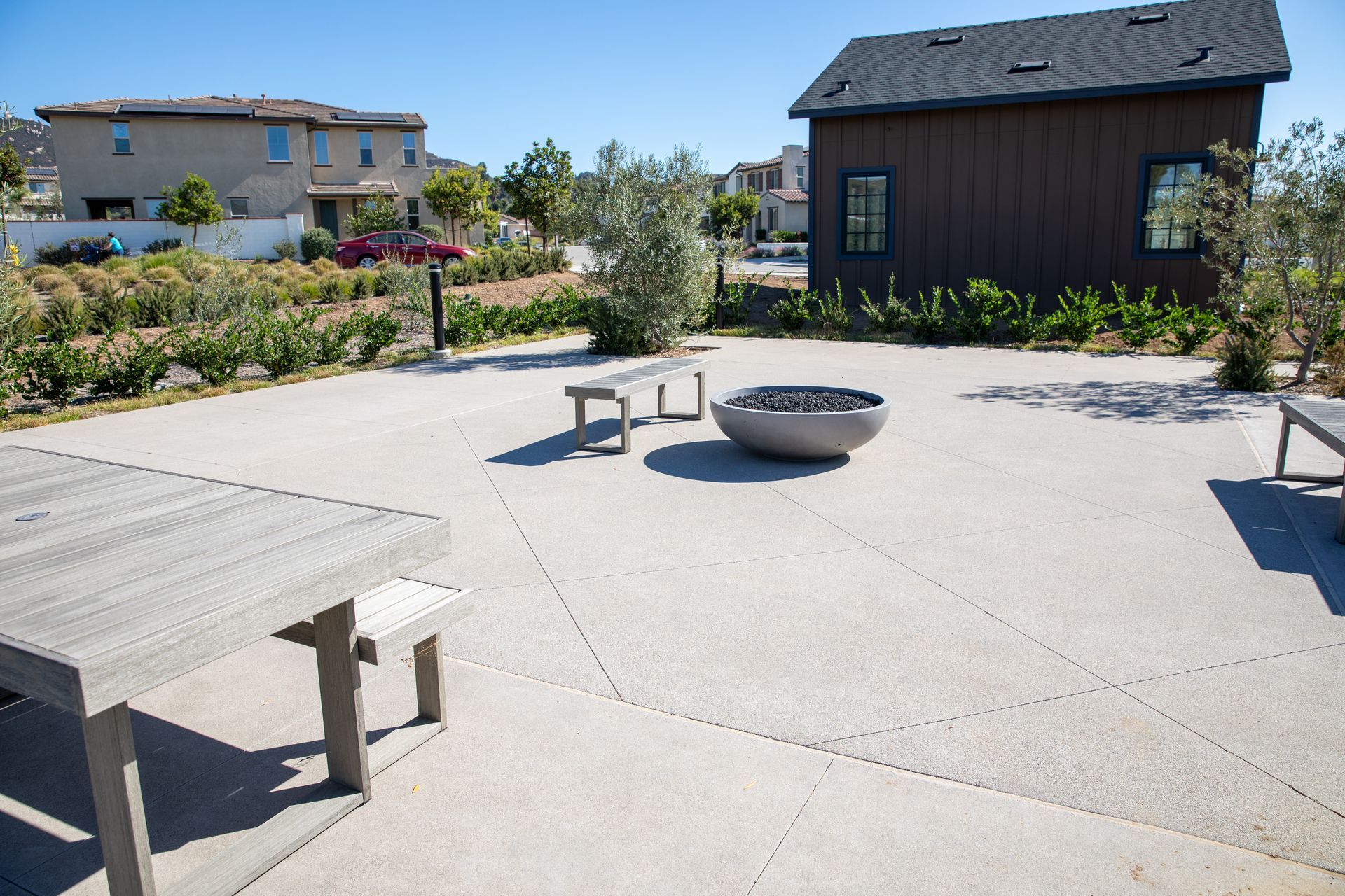 A patio with a picnic table and a fire pit