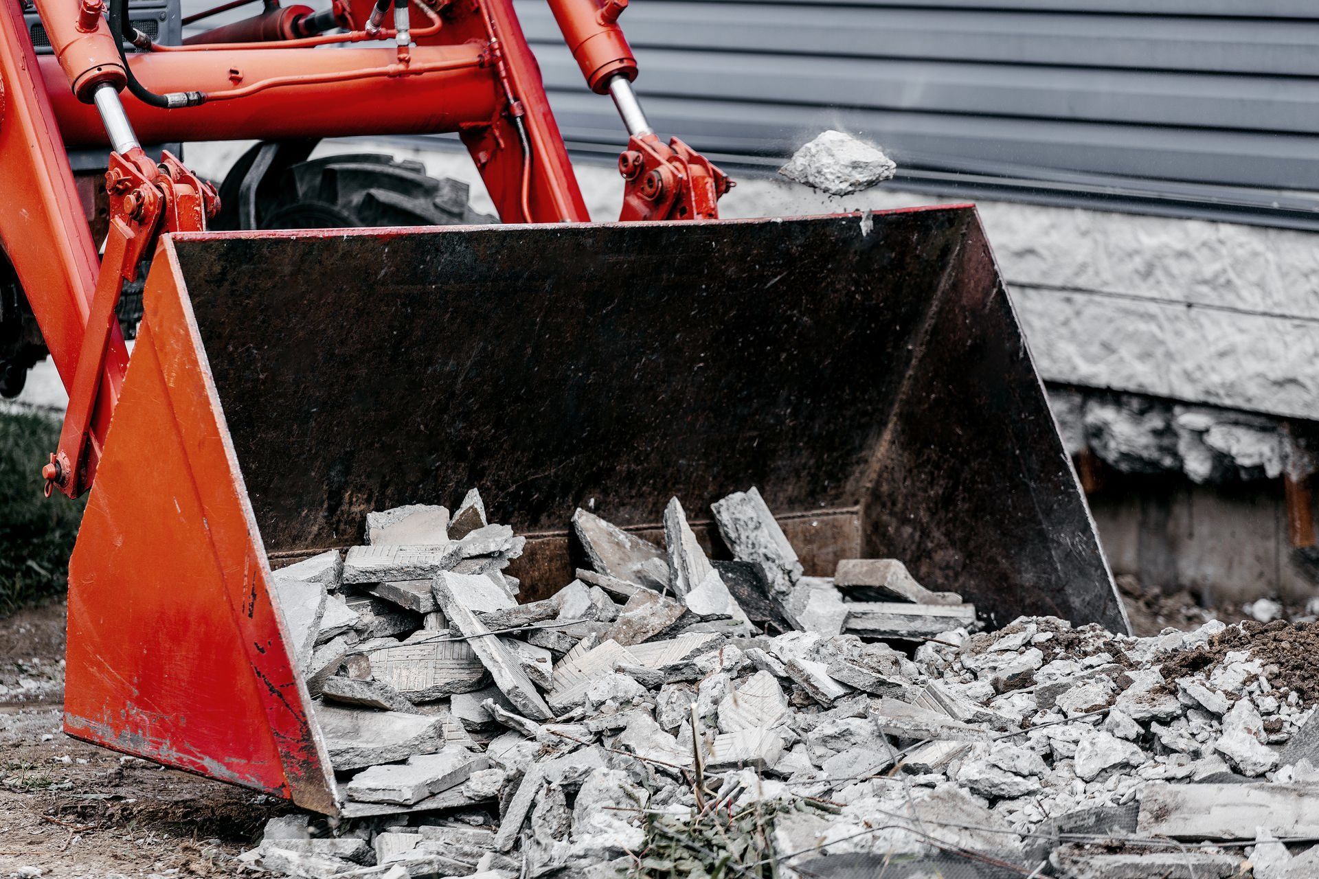A bulldozer is scooping up rocks from the ground.