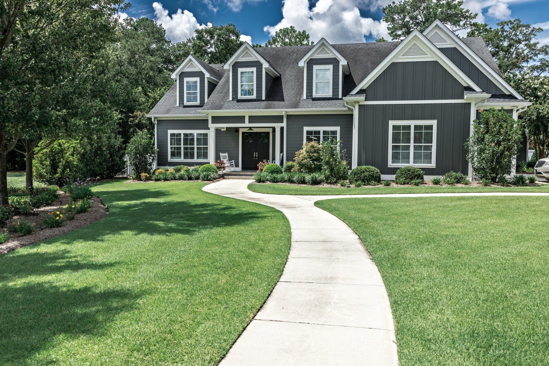 A large house with a concrete walkway leading to it