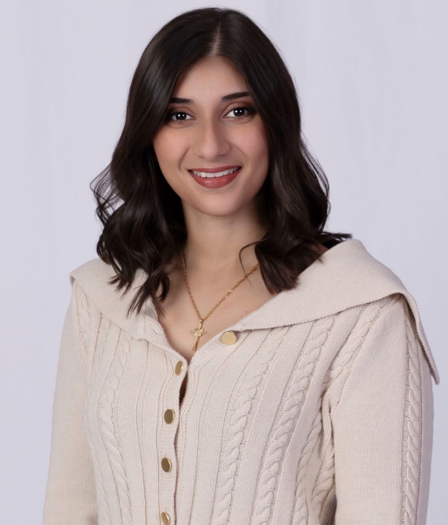 A woman with long brown hair is smiling for the camera
