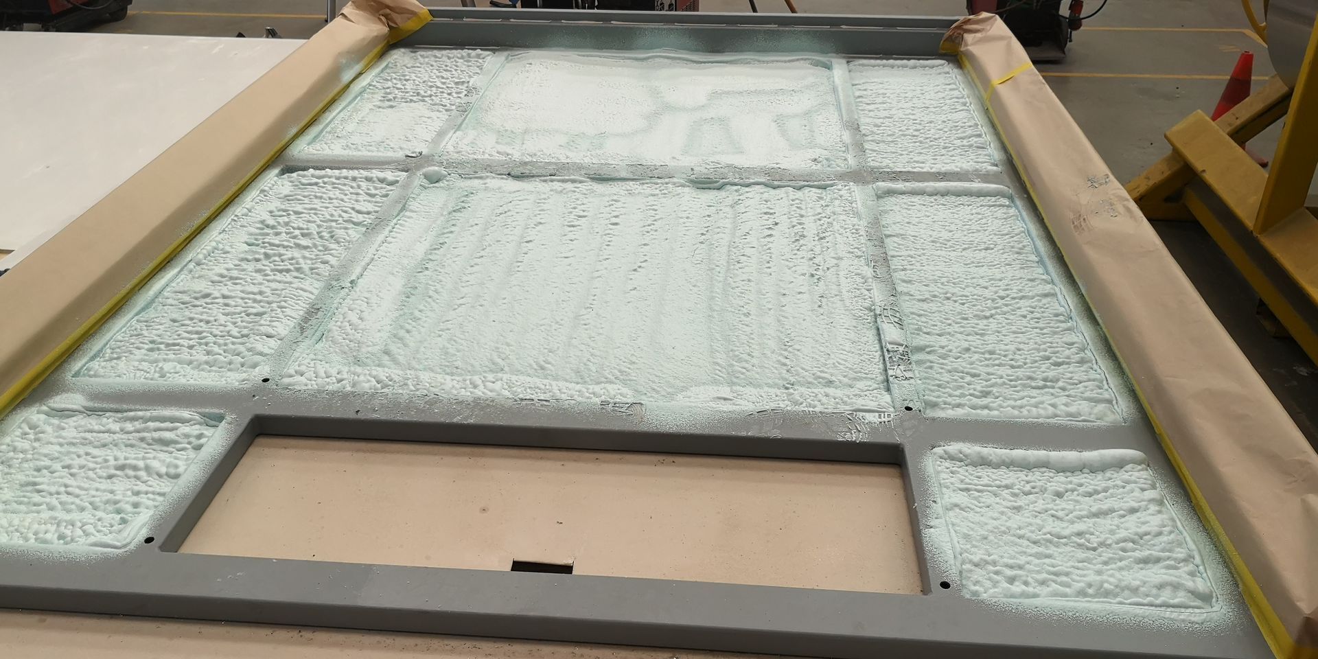 A large piece of glass is sitting on top of a wooden table.