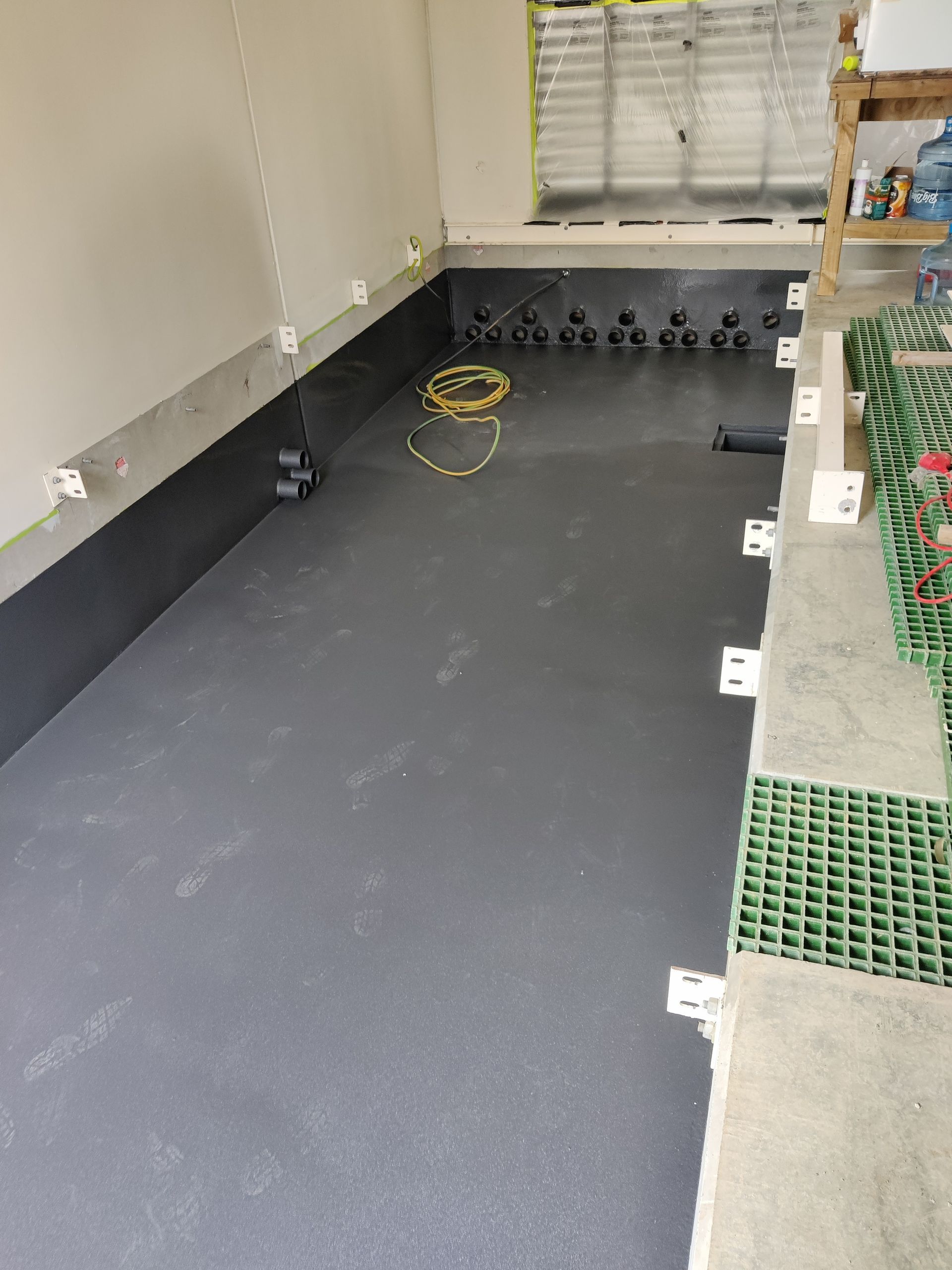 A room with a gray floor and a yellow cord.