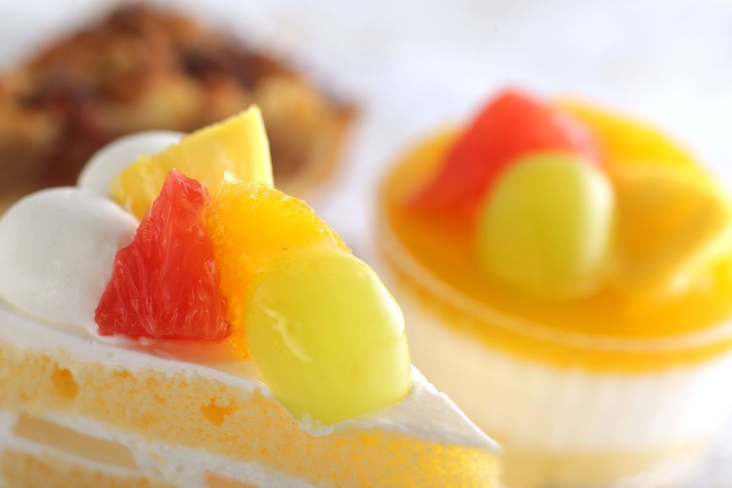 Cupcake con frosting bianco, frutta e decorazioni di gelatina colorata