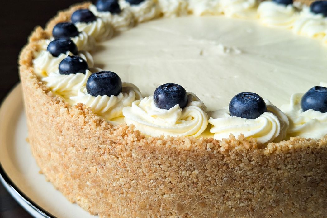 Torta bianca glassata, decorata con mirtilli, servita su un piatto