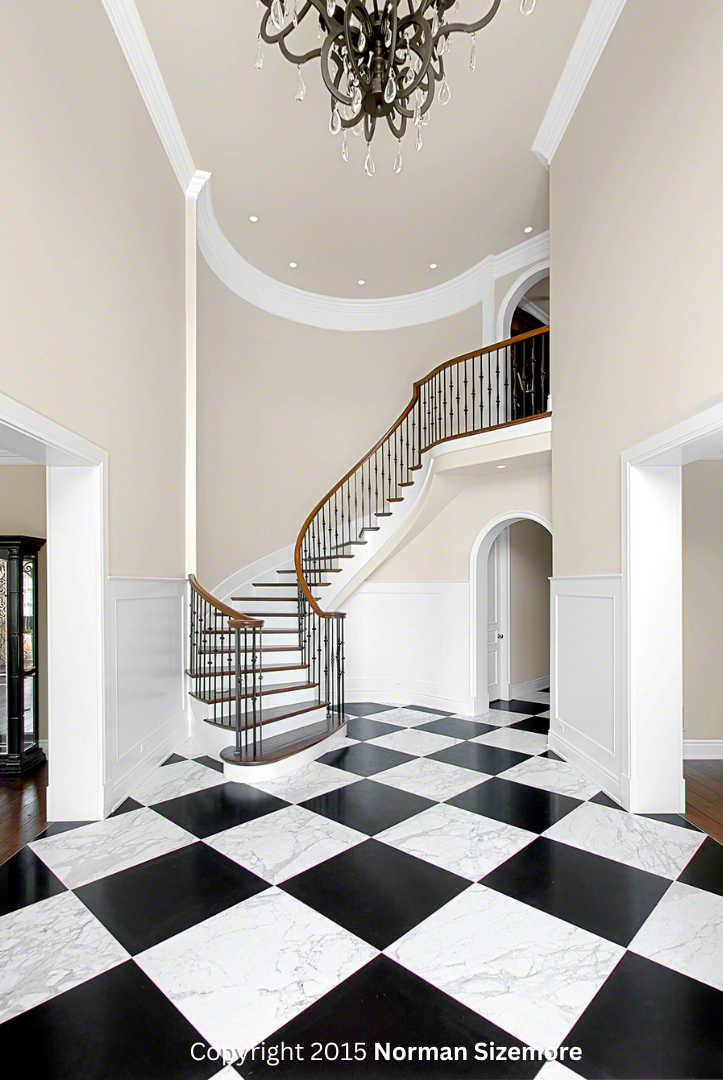 A hallway with a staircase and a checkered floor