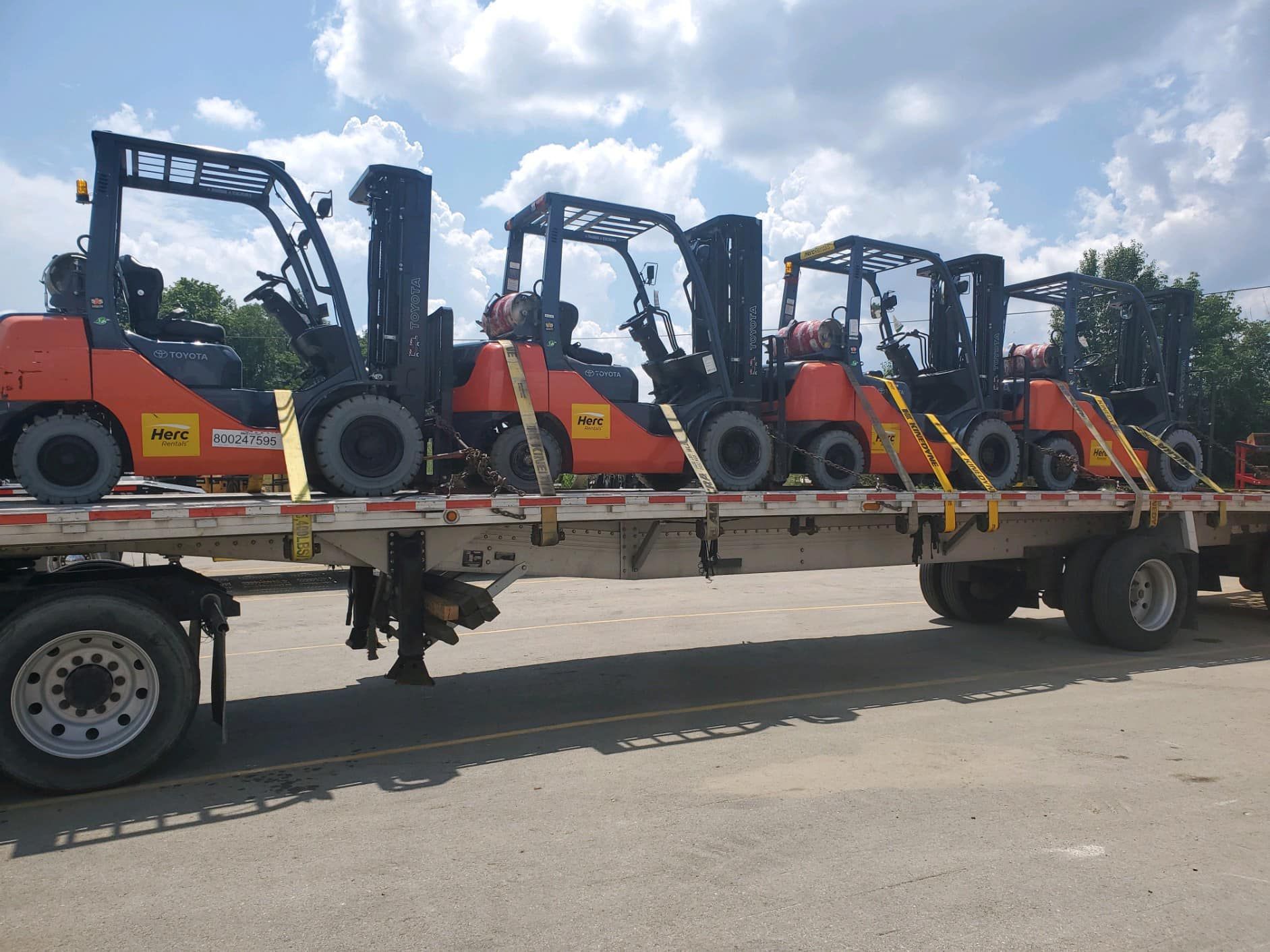 Row of Forklifts Are Sitting on Top of a Trailer