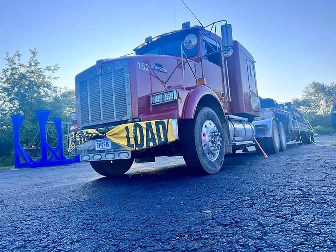 A red semi truck is parked on the side of the road
