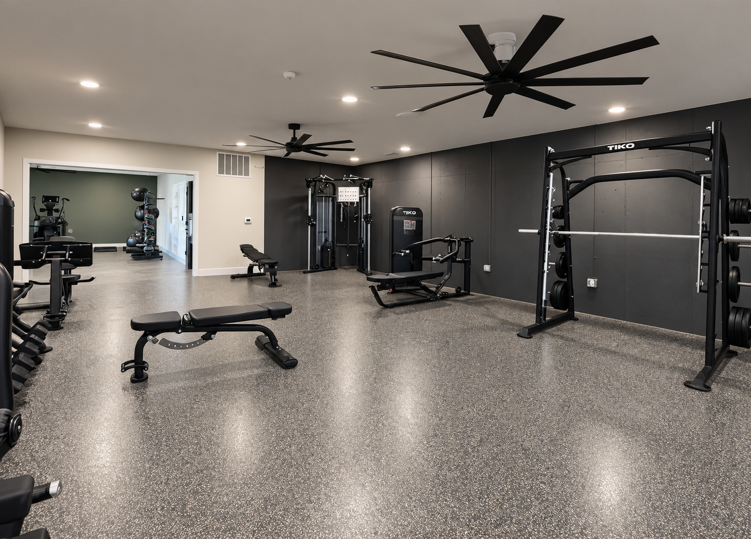 Modern gym with treadmills, weight machines, and light wood floors