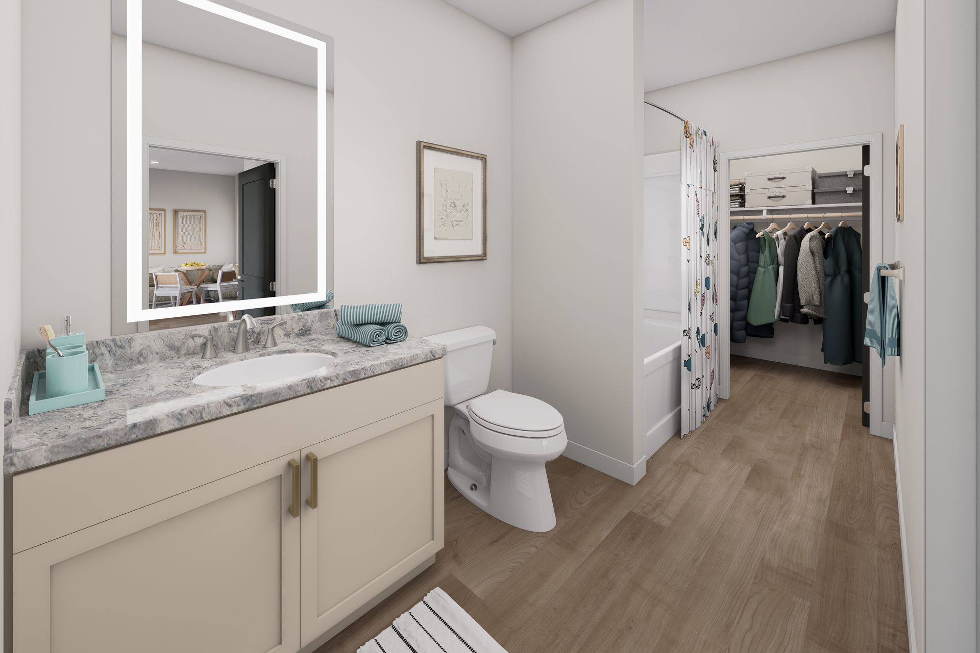 Bright bathroom with white vanity, lit mirror, toilet, and open closet in hallway view