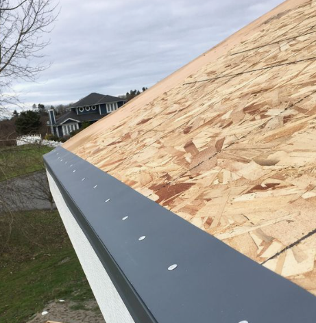 Roof shingles with two small black vents on a sloped rooftop