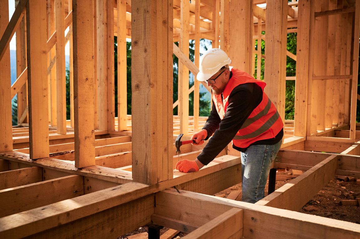 Carpenter hammering wood frame