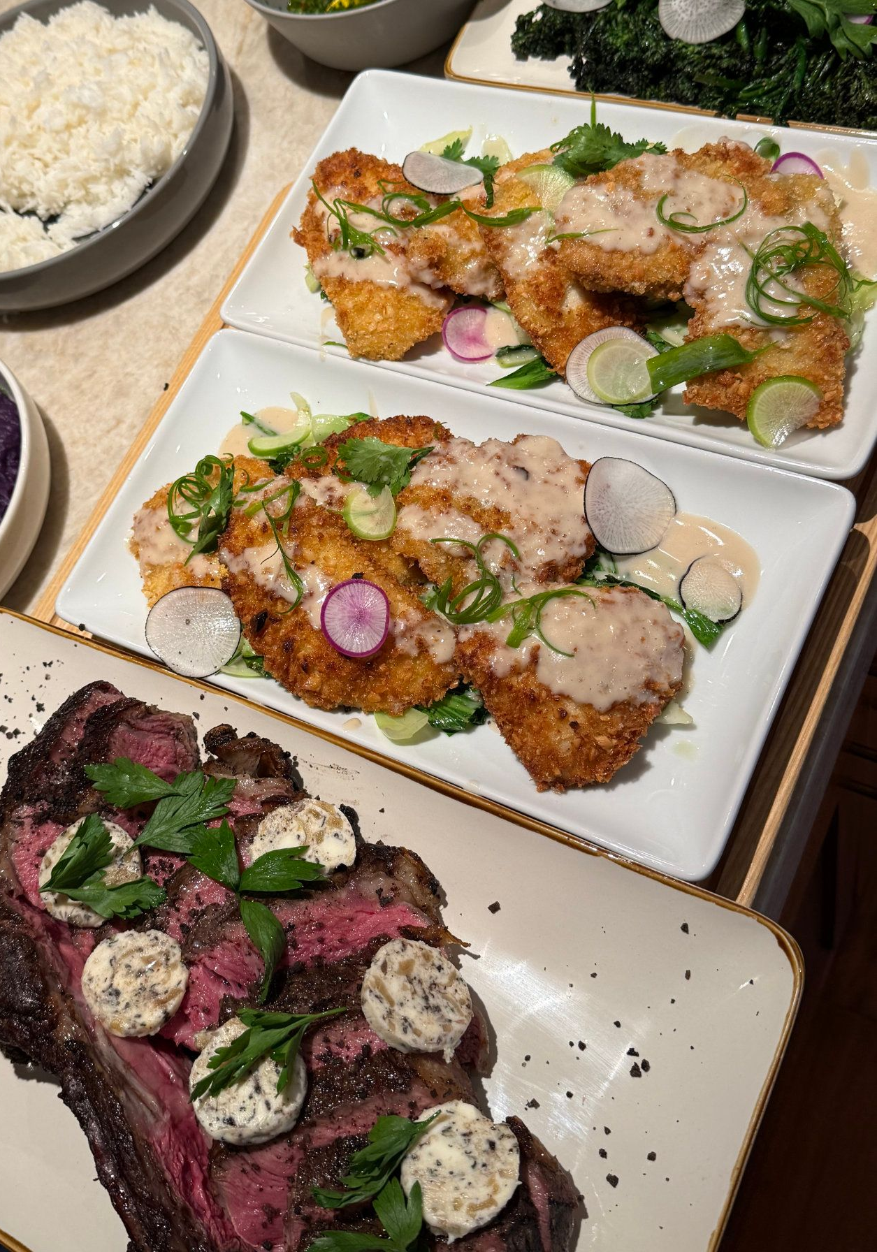 Plated fried cutlets topped with sauce and herbs beside rice, with a beet salad in the foreground.