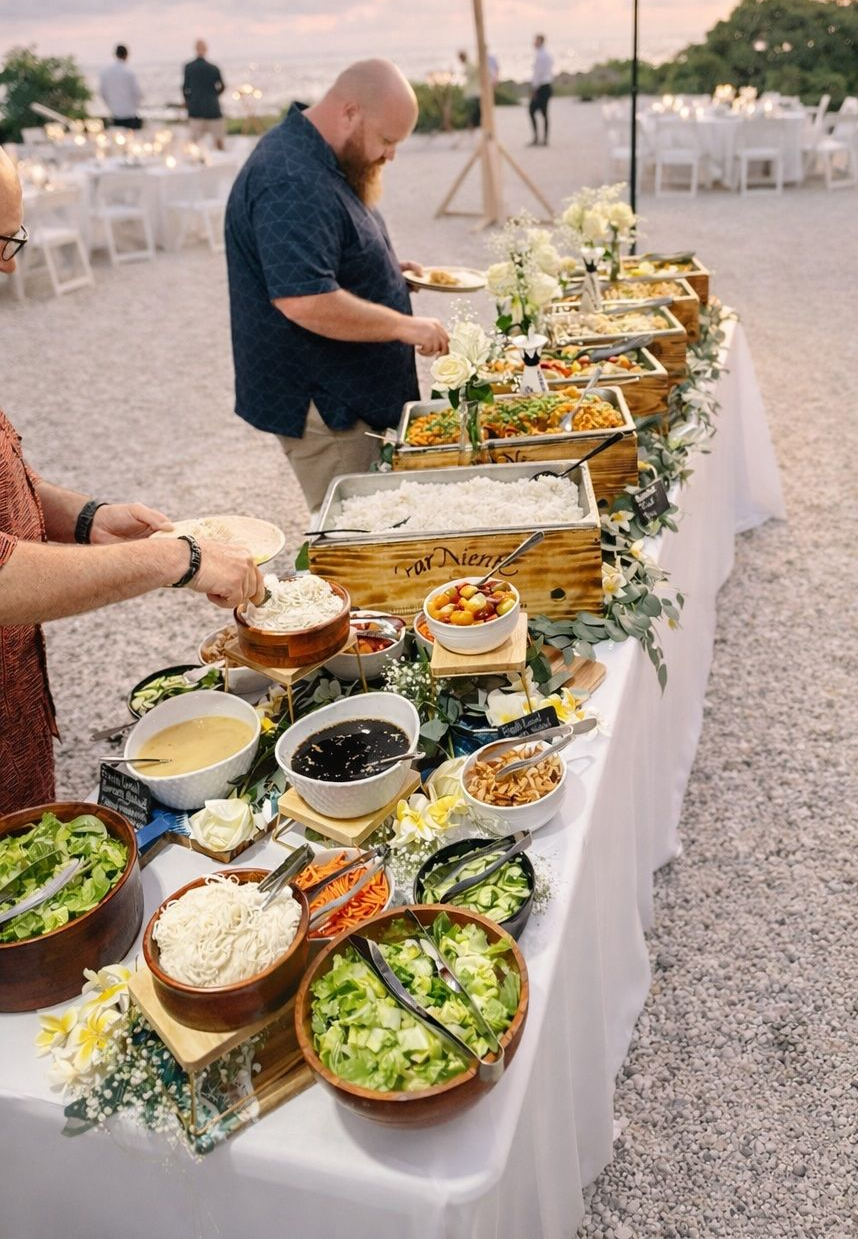 Outdoor buffet table with assorted dishes and a man serving himself at an evening event