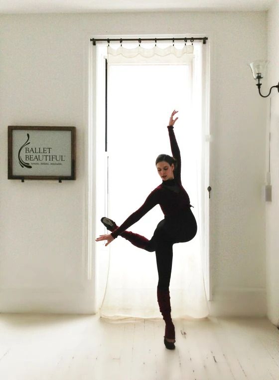 A woman is dancing in front of a sign that says ballet practice