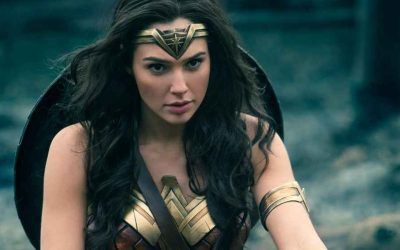 A woman in a wonder woman costume is holding a shield.