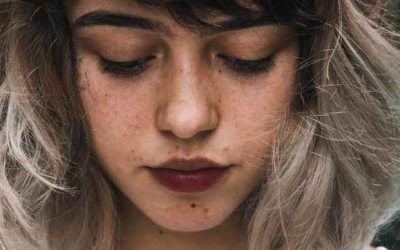 A close up of a woman 's face with her eyes closed.
