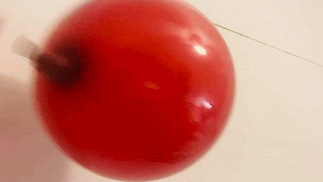 Balloon rocket science experiment demonstrating force and motion with a balloon attached to a straw on a string.