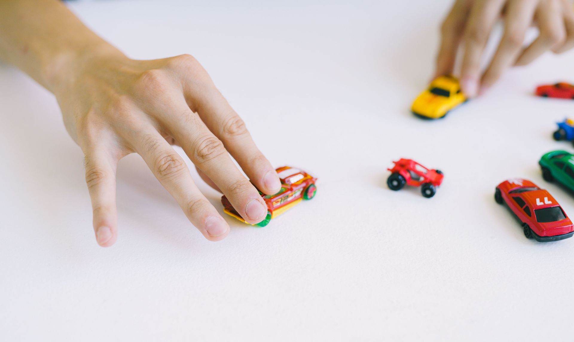 Toy cars being pushed to compare speed and travel time in a force and motion activity.